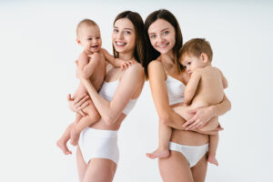 Beautiful women holding baby boys, motherhood and pregnancy conc